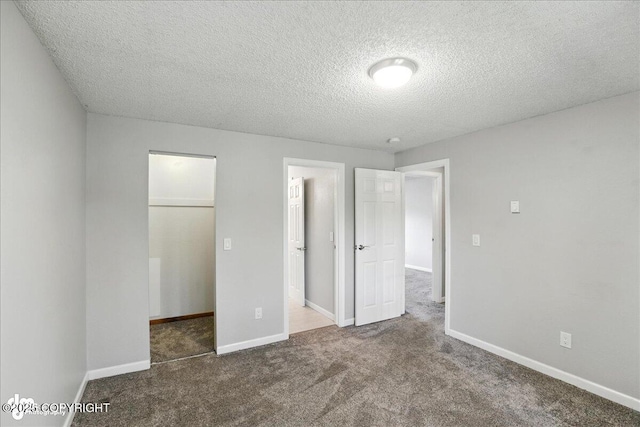 3298 Montpelier Ct Unit 12F, Anchorage, AK 99503 - unfurnished bedroom with a spacious closet, carpet, and a textured ceiling