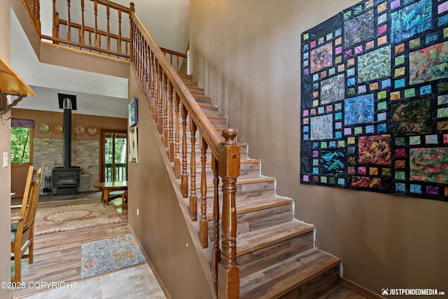 7409 S Timberview Dr, Wasilla, AK 99623 - stairway with a towering ceiling, a wood stove, and wood finished floors