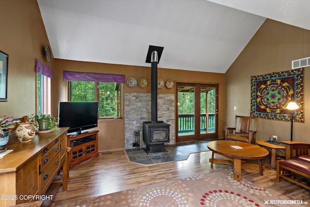 7409 S Timberview Dr, Wasilla, AK 99623 - living room featuring a wood stove, wood finished floors, and high vaulted ceiling