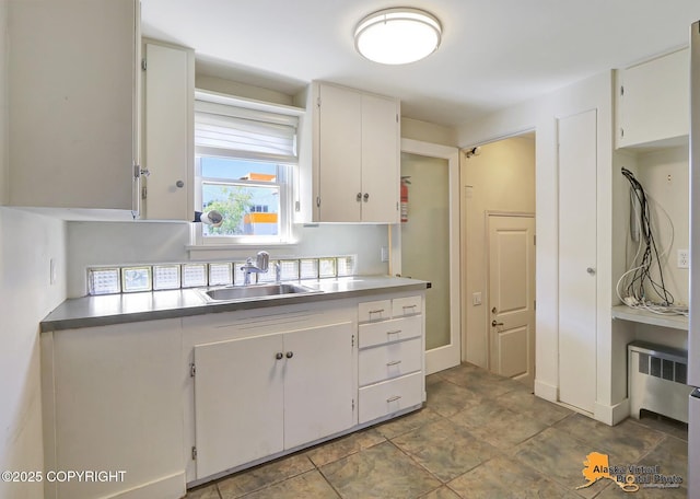 124 E 7th Ave, Anchorage, AK 99501 - kitchen featuring radiator heating unit and white cabinetry