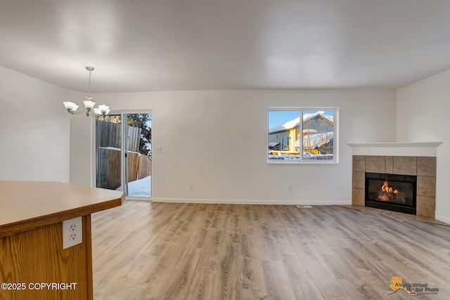 6314 Whispering Loop # 30A, Anchorage, AK 99504 - unfurnished living room featuring healthy amount of natural light, light wood finished floors, and a chandelier