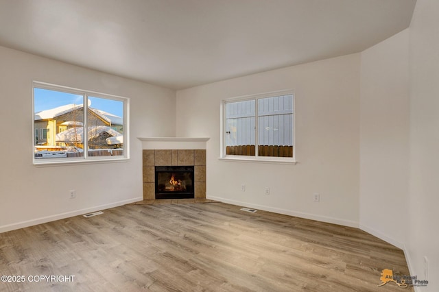 6314 Whispering Loop # 30A, Anchorage, AK 99504 - unfurnished living room with wood finished floors and a tile fireplace