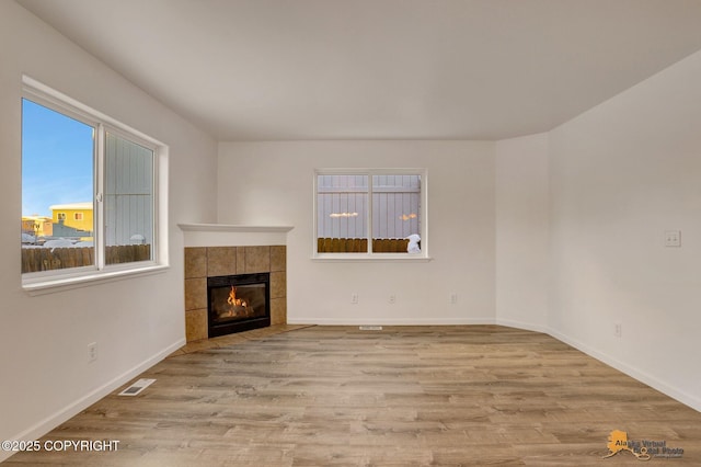 6314 Whispering Loop # 30A, Anchorage, AK 99504 - unfurnished living room featuring wood finished floors and a tile fireplace