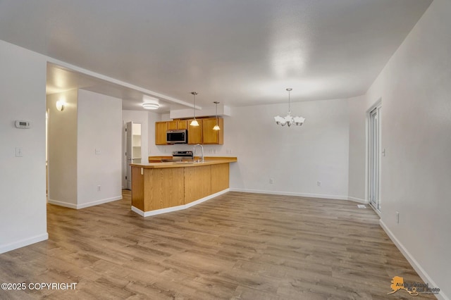 6314 Whispering Loop # 30A, Anchorage, AK 99504 - kitchen featuring appliances with stainless steel finishes, a chandelier, light wood-style flooring, and open floor plan