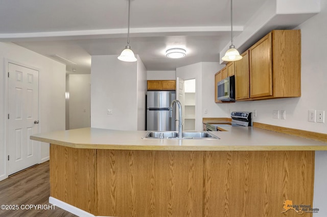 6314 Whispering Loop # 30A, Anchorage, AK 99504 - kitchen featuring stainless steel appliances, a peninsula, brown cabinetry, and pendant lighting