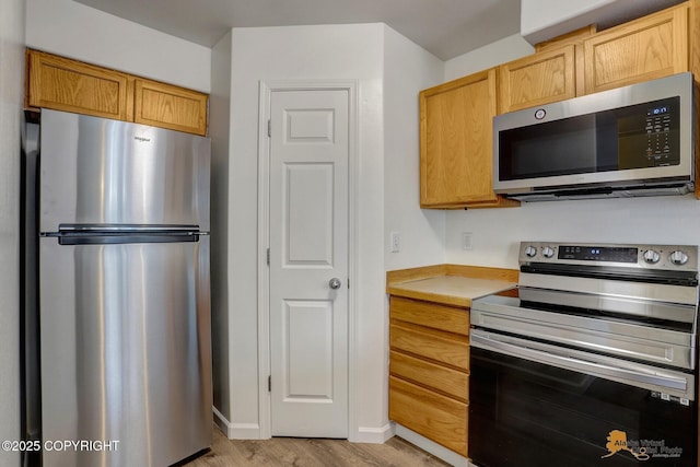 6314 Whispering Loop # 30A, Anchorage, AK 99504 - kitchen featuring appliances with stainless steel finishes, light wood-type flooring, and light countertops