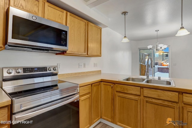 6314 Whispering Loop # 30A, Anchorage, AK 99504 - kitchen with stainless steel appliances, light countertops, a chandelier, decorative light fixtures, and a peninsula