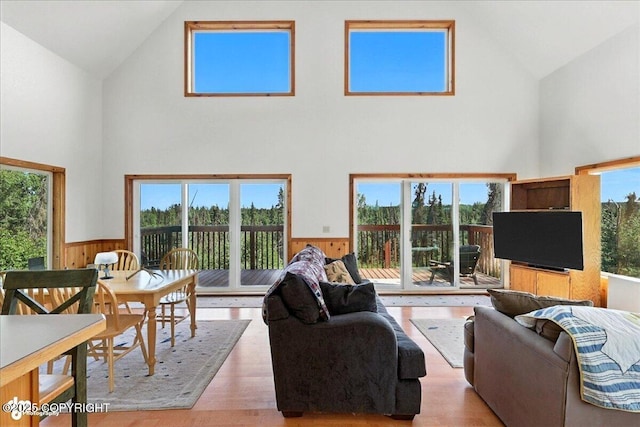 34494 Grizzly Ln, Sterling, AK 99672 - living room featuring high vaulted ceiling, a wainscoted wall, light wood-style flooring, and wood walls