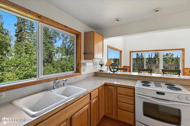34494 Grizzly Ln, Sterling, AK 99672 - kitchen with white electric stove, light countertops, and brown cabinetry