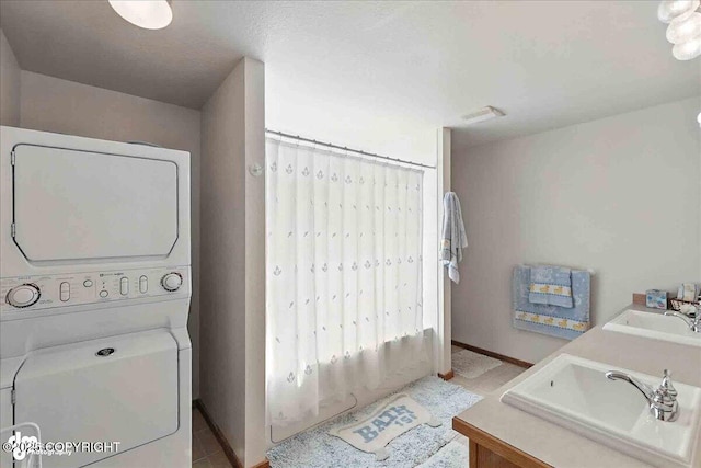 34494 Grizzly Ln, Sterling, AK 99672 - laundry room with stacked washing machine and dryer and baseboards