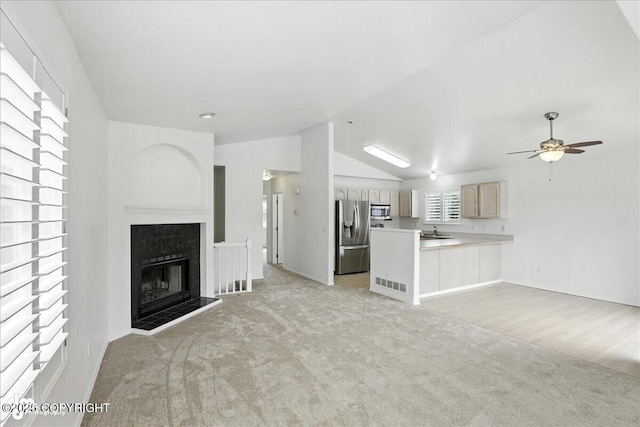 3709 Encore Cir, Anchorage, AK 99507 - unfurnished living room with light carpet, vaulted ceiling, a ceiling fan, and a fireplace with raised hearth