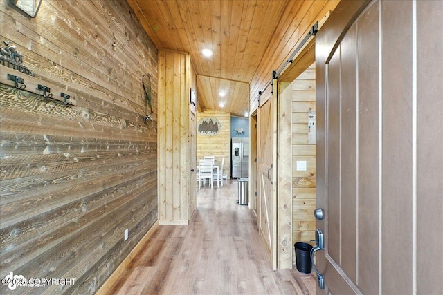23634 Kasilof River Cir, Kasilof, AK 99610 - hallway featuring wood walls, a barn door, wooden ceiling, wood finished floors, and recessed lighting
