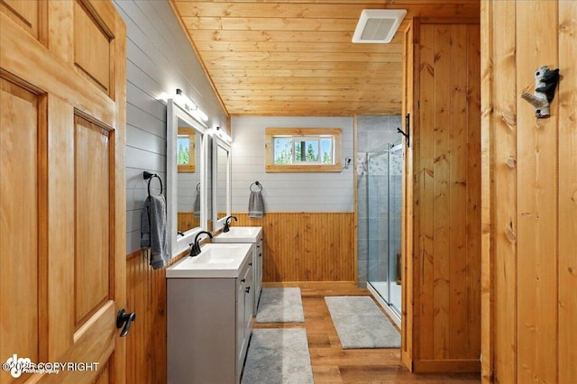 23634 Kasilof River Cir, Kasilof, AK 99610 - bathroom featuring wooden walls, vanity, wooden ceiling, wood finished floors, and a stall shower