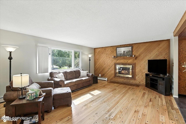 2924 Carnaby Way, Anchorage, AK 99504 - living room with wood walls, hardwood / wood-style floors, a glass covered fireplace, a textured ceiling, and baseboard heating