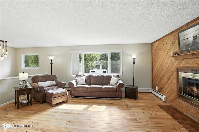 2924 Carnaby Way, Anchorage, AK 99504 - living room featuring wooden walls, a fireplace, light wood-type flooring, a textured ceiling, and a baseboard radiator