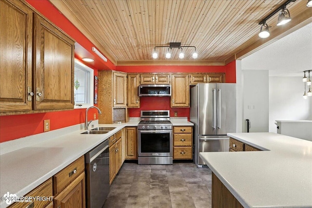2924 Carnaby Way, Anchorage, AK 99504 - kitchen featuring appliances with stainless steel finishes, rail lighting, brown cabinetry, light countertops, and wood ceiling