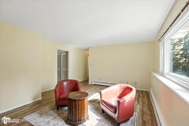 2924 Carnaby Way, Anchorage, AK 99504 - living area with wood finished floors, baseboard heating, a textured ceiling, and a baseboard radiator