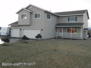 956 S Pinnacle Mountain Dr, Palmer, AK 99645 - traditional-style house with an attached garage, covered porch, and stucco siding