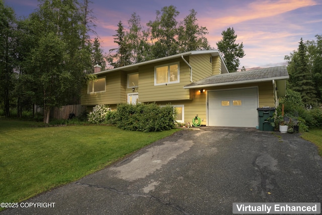 10711 Colville St, Eagle River, AK 99577 - split foyer home featuring an attached garage, asphalt driveway, a yard, and a chimney