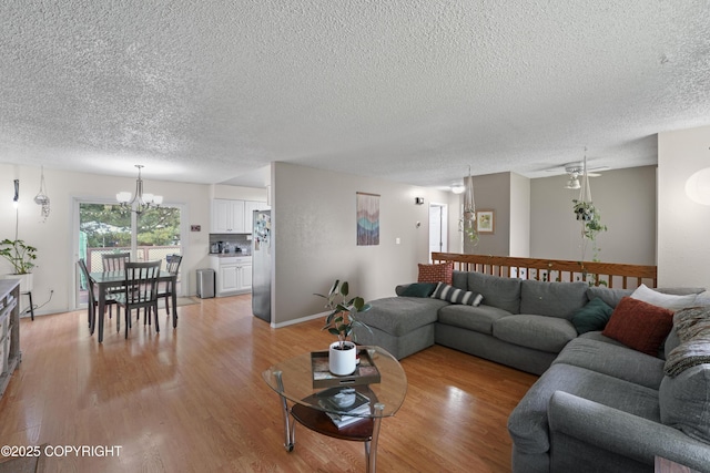 10711 Colville St, Eagle River, AK 99577 - living area with a textured ceiling, a chandelier, light wood-style flooring, and ceiling fan