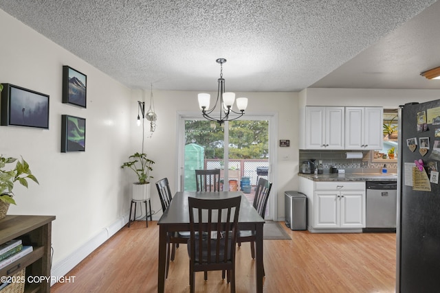 10711 Colville St, Eagle River, AK 99577 - dining area featuring a textured ceiling, light wood-style flooring, and a chandelier