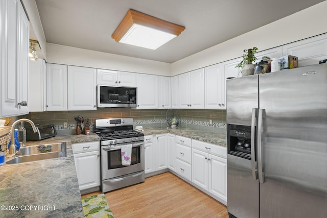 10711 Colville St, Eagle River, AK 99577 - kitchen with appliances with stainless steel finishes, decorative backsplash, and white cabinetry