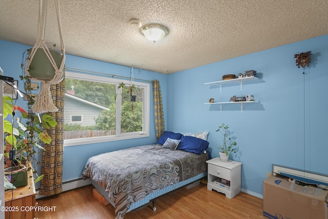 10711 Colville St, Eagle River, AK 99577 - bedroom with a baseboard radiator, a textured ceiling, and wood finished floors
