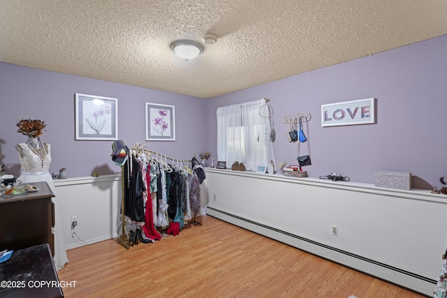 10711 Colville St, Eagle River, AK 99577 - interior space with a baseboard heating unit, wood finished floors, and a textured ceiling