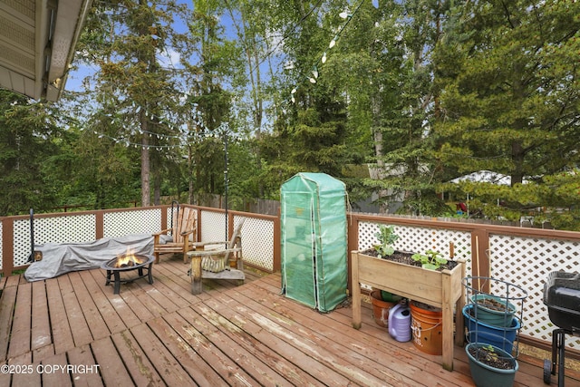 10711 Colville St, Eagle River, AK 99577 - wooden terrace featuring an outdoor fire pit and view of scattered trees