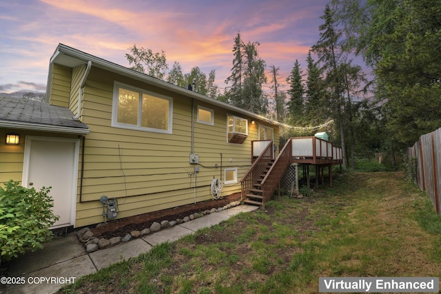 10711 Colville St, Eagle River, AK 99577 - back of property at dusk featuring stairway and a wooden deck
