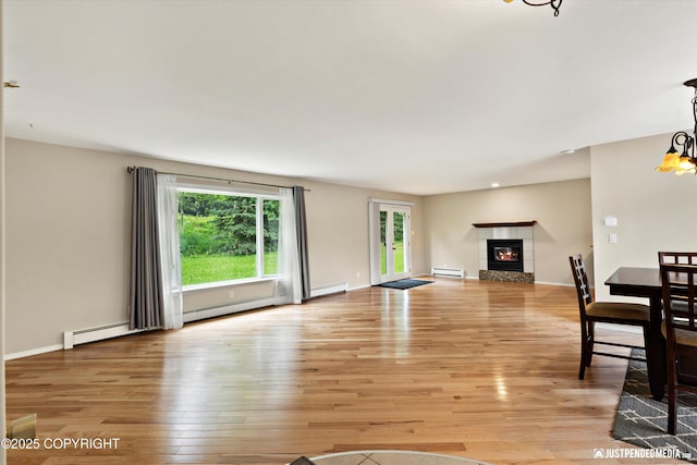 15201 Pollock Dr, Anchorage, AK 99516 - unfurnished living room with baseboard heating, light wood-style flooring, and a fireplace
