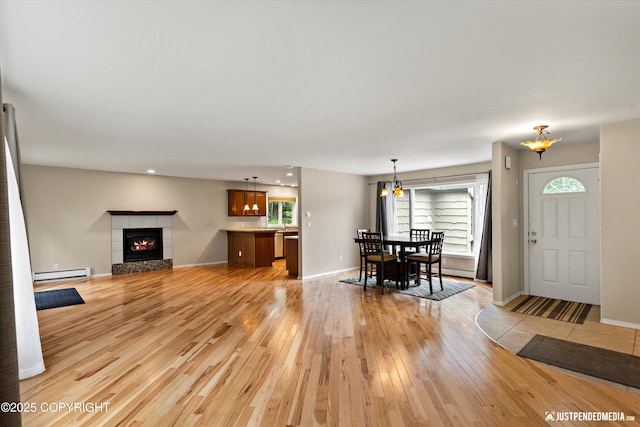 15201 Pollock Dr, Anchorage, AK 99516 - living room with baseboard heating, light wood-style flooring, a tile fireplace, plenty of natural light, and recessed lighting