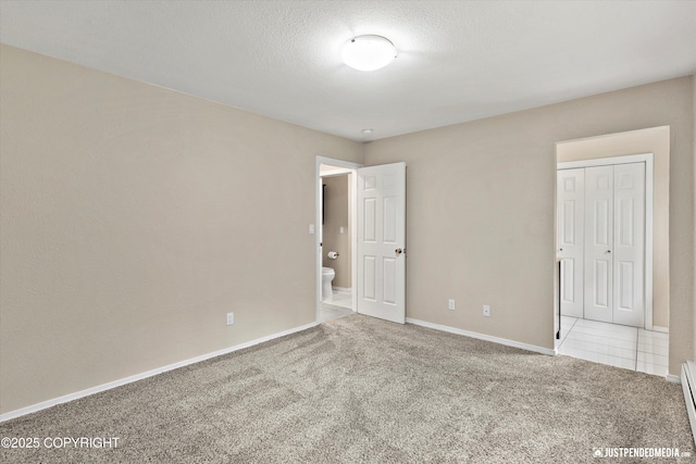 15201 Pollock Dr, Anchorage, AK 99516 - unfurnished bedroom featuring carpet floors, baseboard heating, a closet, and a textured ceiling