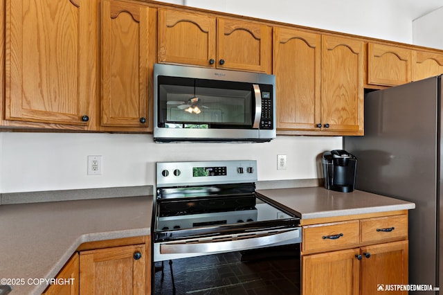 2666 Lauren Creek Loop # 23, Anchorage, AK 99507 - kitchen with appliances with stainless steel finishes, brown cabinetry, and light countertops