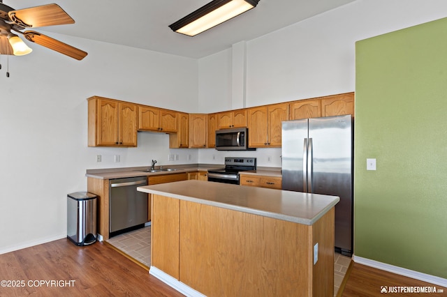 2666 Lauren Creek Loop # 23, Anchorage, AK 99507 - kitchen with stainless steel appliances, high vaulted ceiling, ceiling fan, wood finished floors, and a center island
