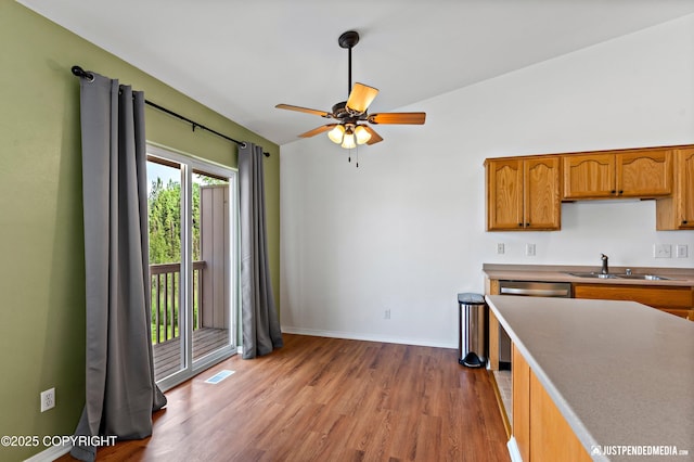 2666 Lauren Creek Loop # 23, Anchorage, AK 99507 - kitchen with light wood finished floors, ceiling fan, brown cabinets, stainless steel dishwasher, and light countertops