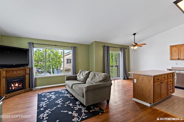 2666 Lauren Creek Loop # 23, Anchorage, AK 99507 - living room featuring a glass covered fireplace, ceiling fan, lofted ceiling, and wood finished floors
