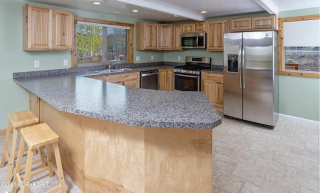 8011 Stewart Mountain Dr, Eagle River, AK 99577 - kitchen with appliances with stainless steel finishes, a peninsula, recessed lighting, light stone finish flooring, and a breakfast bar area