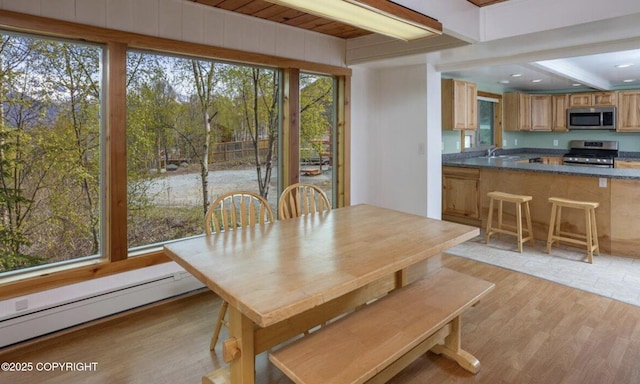 8011 Stewart Mountain Dr, Eagle River, AK 99577 - dining space featuring a baseboard heating unit, light wood finished floors, and beamed ceiling