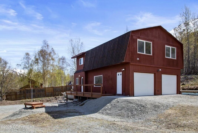 8011 Stewart Mountain Dr, Eagle River, AK 99577 - view of front of house featuring a gambrel roof, roof with shingles, a garage, and driveway