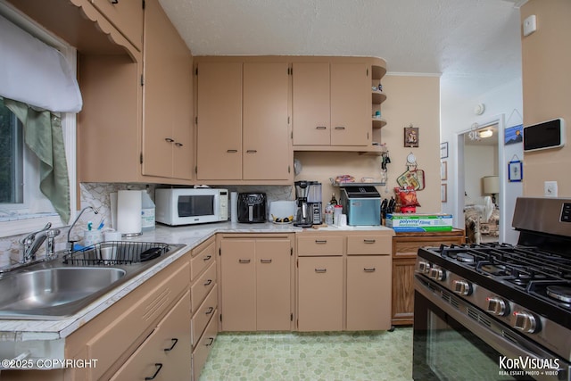 203 S Cobb St, Palmer, AK 99645 - kitchen featuring stainless steel gas stove, white microwave, light countertops, cream cabinetry, and a textured ceiling