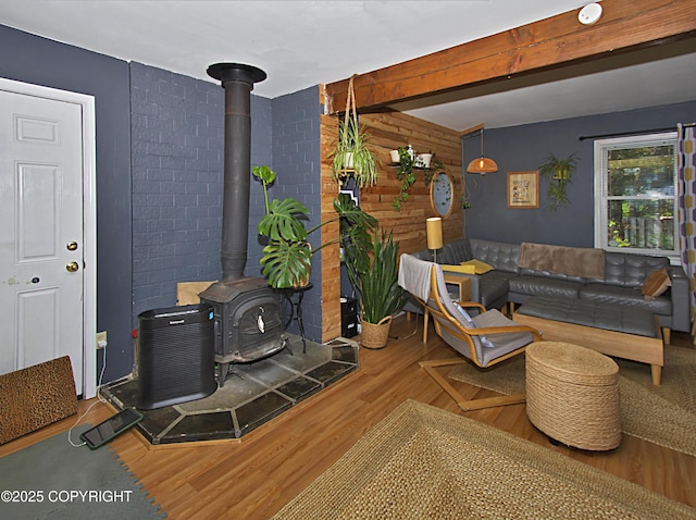213 Lee Dr, Homer, AK 99603 - living area featuring a wood stove, wood finished floors, beam ceiling, and wooden walls