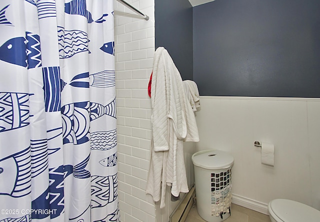 213 Lee Dr, Homer, AK 99603 - bathroom featuring a wainscoted wall, a shower with shower curtain, baseboard heating, and tile patterned floors