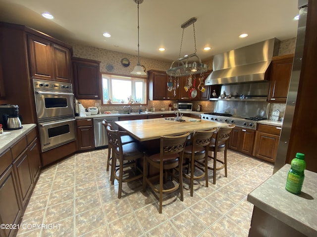 60871 Bear Creek Dr, Homer, AK 99603 - kitchen with appliances with stainless steel finishes, exhaust hood, backsplash, recessed lighting, and light tile patterned flooring