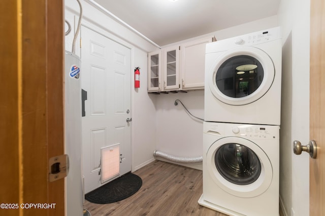 3237 Lincoln Ct, Ketchikan, AK 99901 - laundry area featuring stacked washer / drying machine, wood finished floors, and cabinet space
