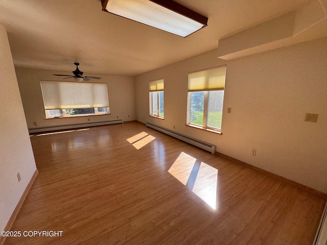 16297 E Harter Dr, Palmer, AK 99645 - empty room featuring a baseboard radiator, wood finished floors, and ceiling fan