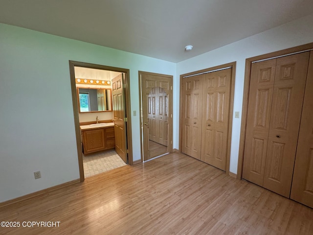 16297 E Harter Dr, Palmer, AK 99645 - unfurnished bedroom with multiple closets, light wood-style flooring, and ensuite bathroom