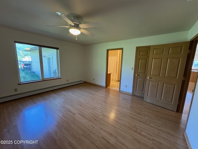 16297 E Harter Dr, Palmer, AK 99645 - unfurnished bedroom featuring wood finished floors, multiple windows, a baseboard heating unit, and ensuite bathroom