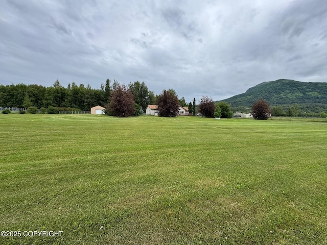 16297 E Harter Dr, Palmer, AK 99645 - view of green lawn with a mountain view, a view of countryside, and an outdoor structure