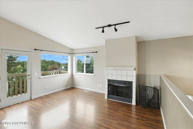 10300 Ridge Park Dr, Anchorage, AK 99507 - unfurnished living room with track lighting, wood finished floors, a tile fireplace, and lofted ceiling